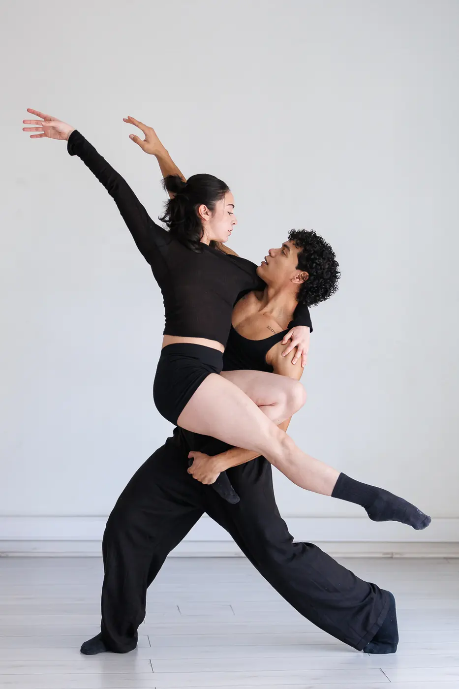 Bailarina clásica con tutú blanco sobre puntas y los brazos en alto