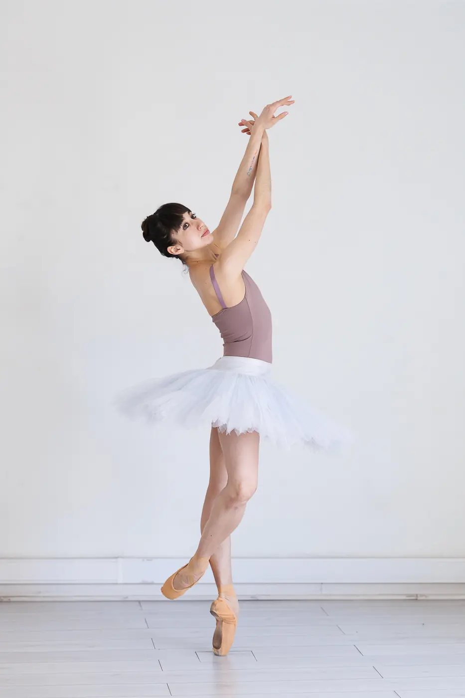 Bailarina de folclor chileno con vestido floreado, levantando un pañuelo blanco