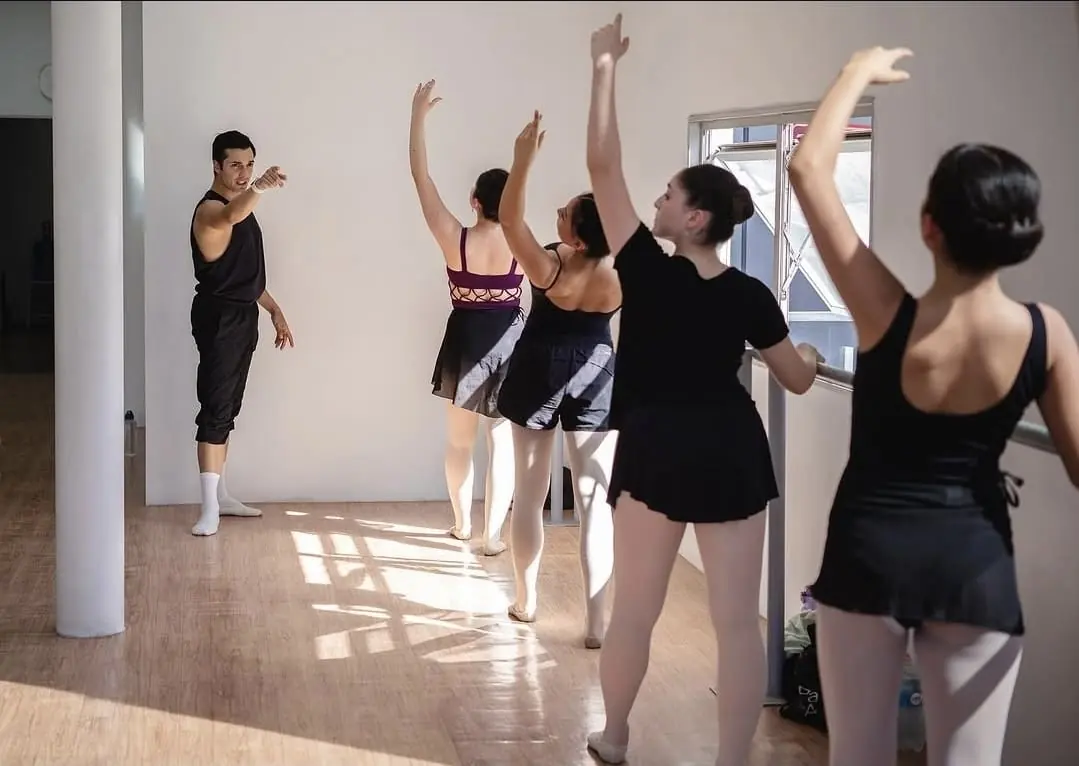 Clase en el estudio de Ballet Training Chile: alumnas con los brazos en alto siguiendo al profesor